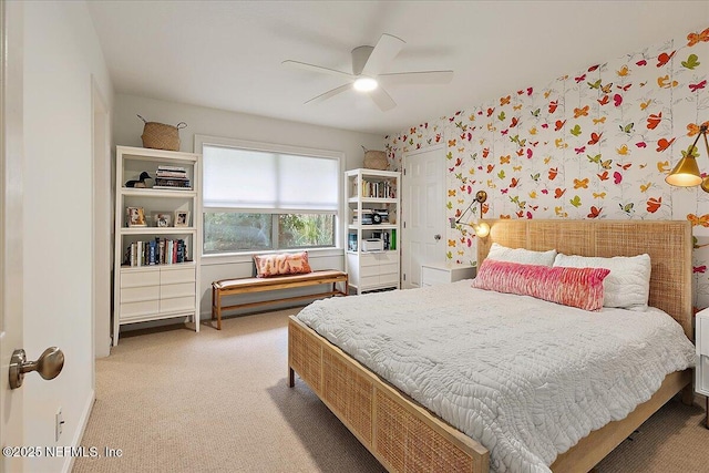 bedroom with light colored carpet, a ceiling fan, and wallpapered walls