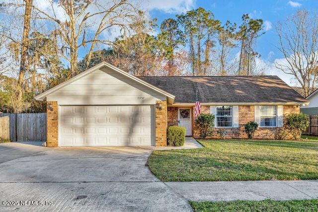 single story home featuring a front yard and a garage