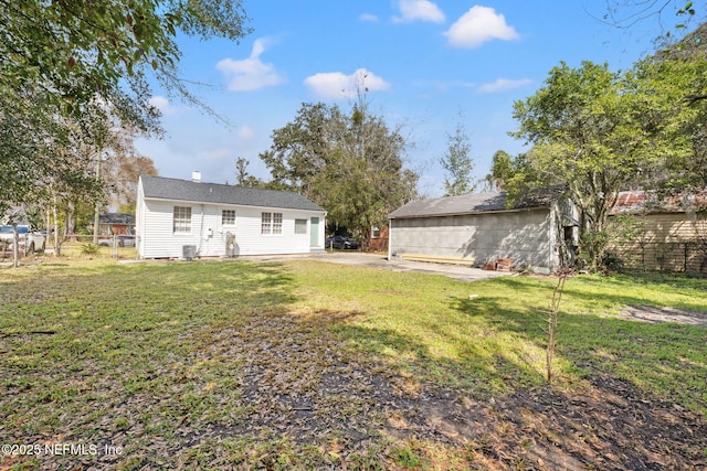 back of property featuring a yard, an outbuilding, fence, and a chimney