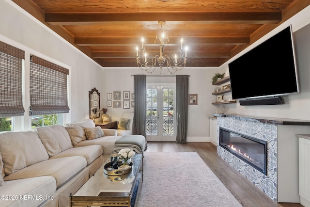 living room featuring hardwood / wood-style floors, a chandelier, wooden ceiling, french doors, and beam ceiling