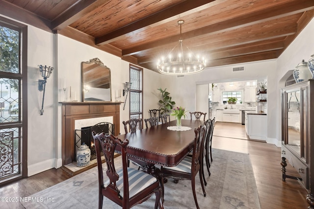 dining room featuring hardwood / wood-style floors, an inviting chandelier, beamed ceiling, and wooden ceiling