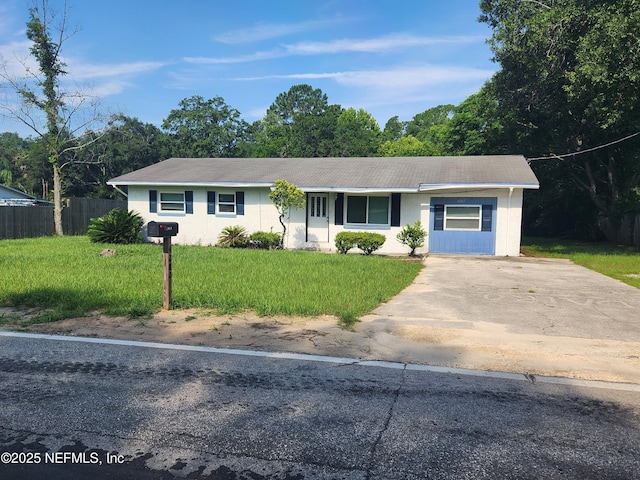 ranch-style home featuring a front yard, concrete driveway, and fence