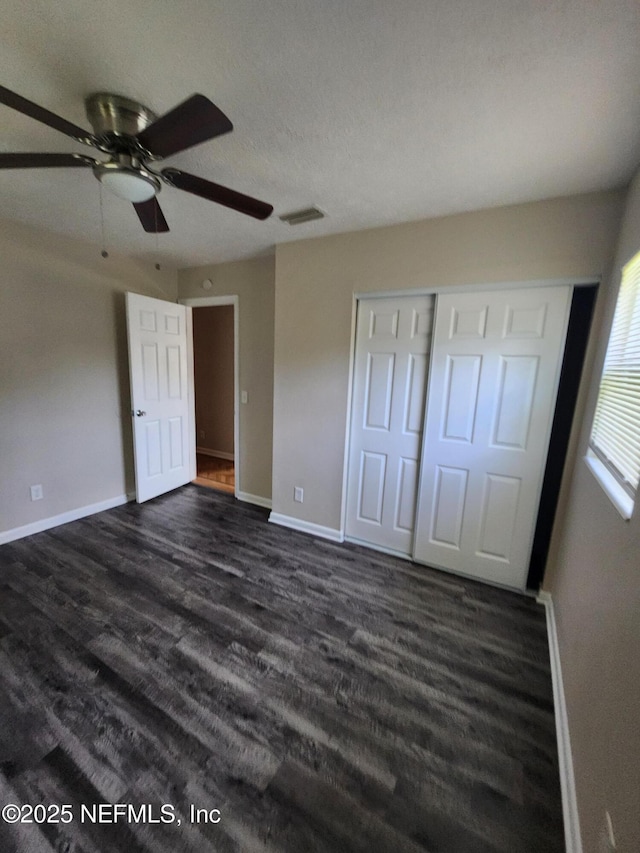 unfurnished bedroom with dark wood-style flooring and baseboards