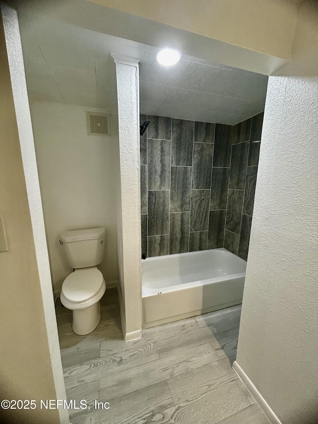 bathroom featuring shower / bathtub combination, visible vents, toilet, and baseboards