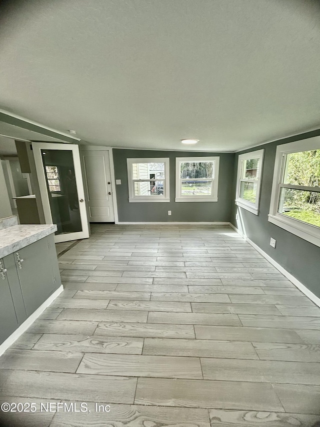 unfurnished living room with light wood-style floors and baseboards