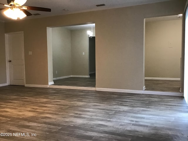 spare room featuring a ceiling fan, wood finished floors, visible vents, and baseboards