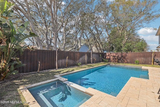 view of pool featuring a fenced backyard and a pool with connected hot tub