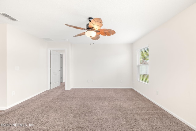 carpeted spare room featuring ceiling fan