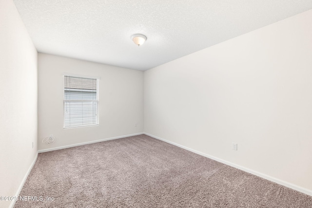 carpeted empty room with a textured ceiling