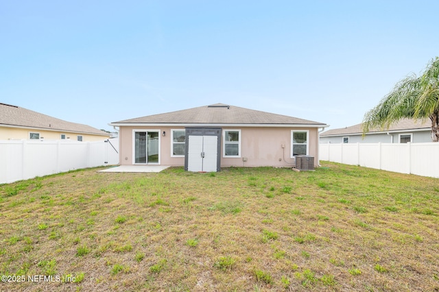 back of property with a patio area, cooling unit, and a lawn