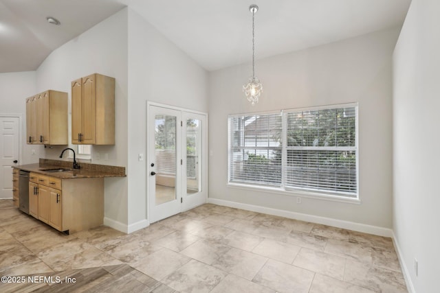 kitchen featuring light brown cabinets, a sink, baseboards, dishwasher, and pendant lighting