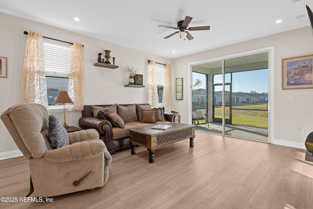 living room featuring a ceiling fan, recessed lighting, light wood-style flooring, and baseboards