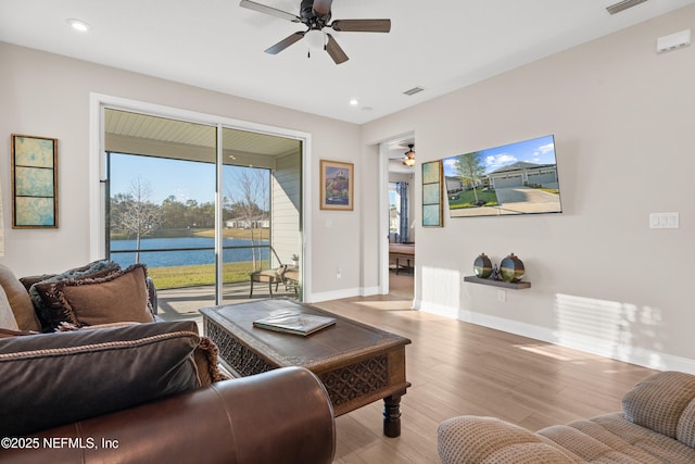 living room featuring light wood-type flooring, visible vents, ceiling fan, and baseboards