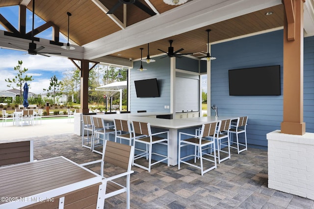 view of patio / terrace with a ceiling fan and a bar