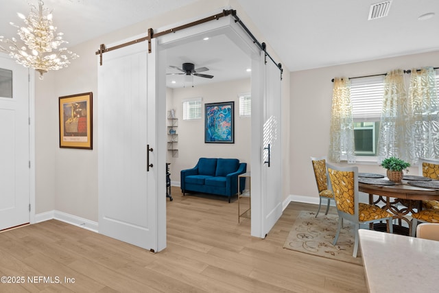 entryway featuring visible vents, a barn door, and light wood-style flooring