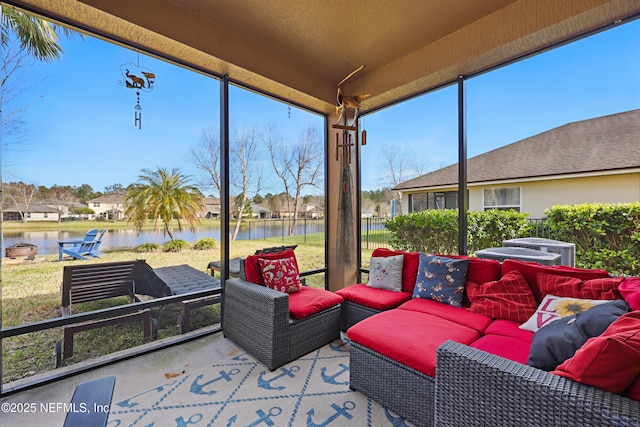 sunroom featuring a water view