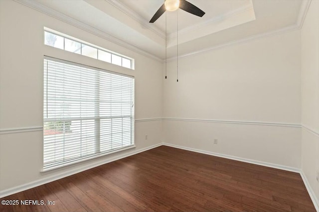 unfurnished room featuring ceiling fan, ornamental molding, a tray ceiling, and dark hardwood / wood-style floors