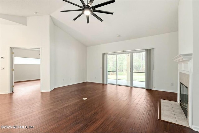 unfurnished living room with high vaulted ceiling, ceiling fan, hardwood / wood-style flooring, and a tile fireplace