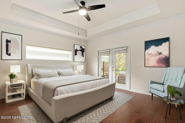 bedroom featuring a tray ceiling, dark wood-type flooring, ornamental molding, and access to outside