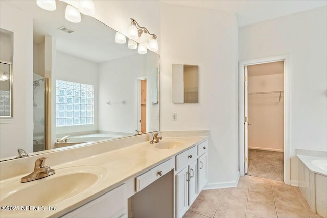 bathroom with tile patterned flooring, separate shower and tub, and vanity