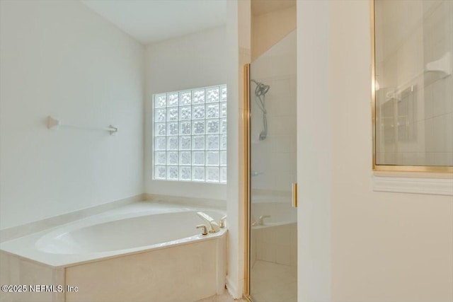 bathroom featuring shower with separate bathtub