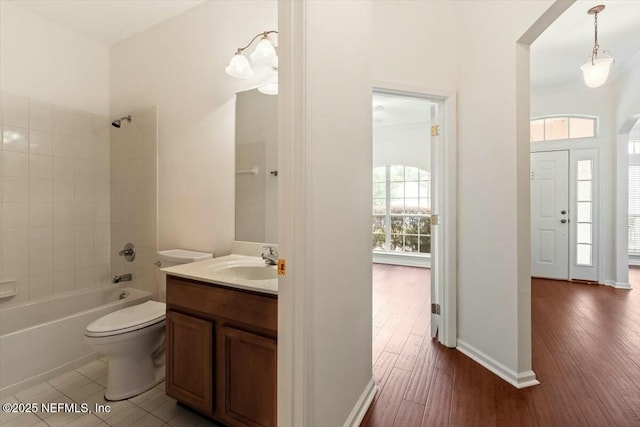 full bathroom with tiled shower / bath, wood-type flooring, vanity, and toilet