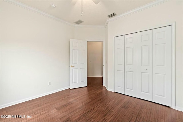 unfurnished bedroom featuring dark hardwood / wood-style flooring, crown molding, ceiling fan, and a closet