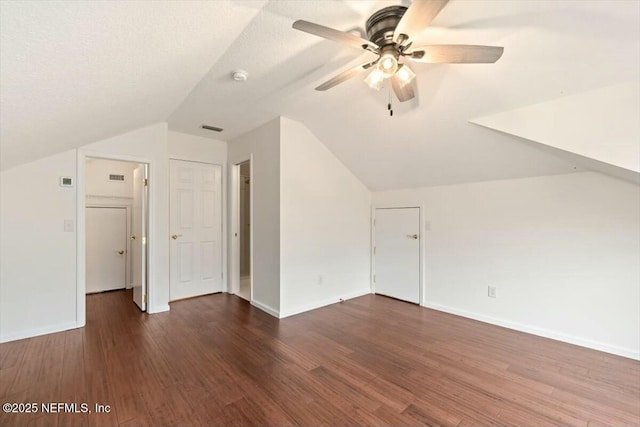 bonus room with dark hardwood / wood-style flooring, a textured ceiling, and vaulted ceiling