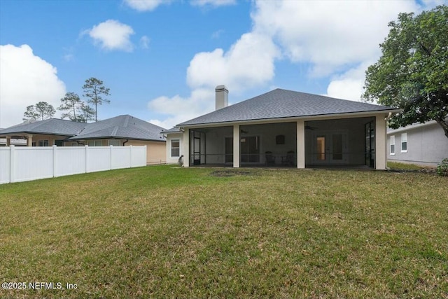 back of house with a lawn and a sunroom