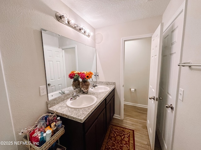 bathroom featuring a textured ceiling, hardwood / wood-style flooring, and vanity