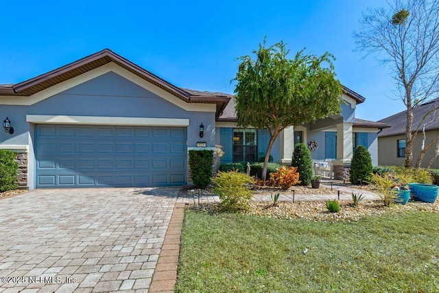 view of front of home with a garage, decorative driveway, and stucco siding