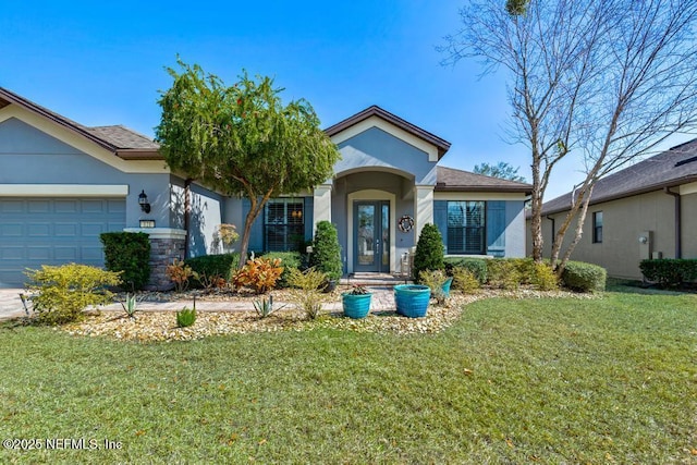 view of front of house featuring a garage, a front lawn, and stucco siding