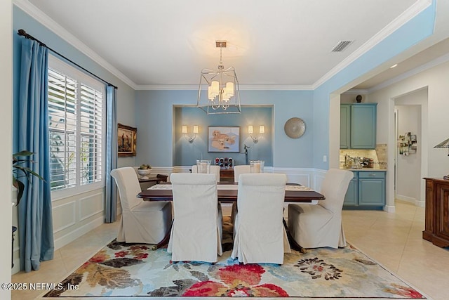 dining room with a chandelier, light tile patterned floors, and crown molding