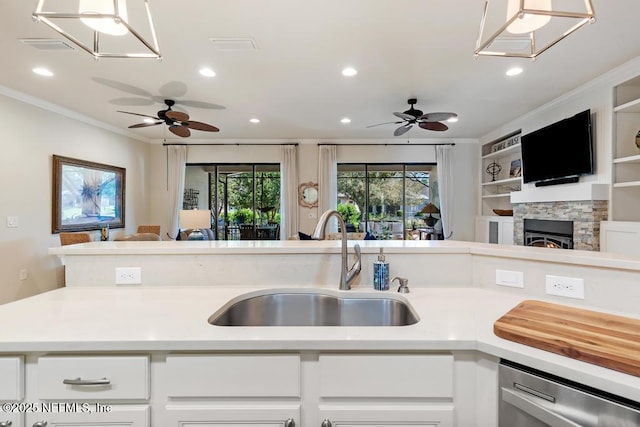 kitchen with white cabinets, open floor plan, a sink, and light countertops