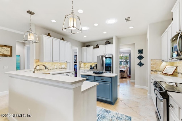 kitchen with light tile patterned floors, stainless steel appliances, blue cabinetry, and light countertops