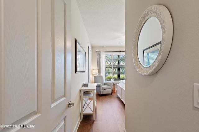 hall featuring wood finished floors and baseboards