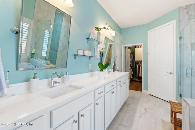 bathroom featuring double vanity, a stall shower, marble finish floor, and a sink