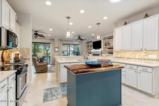 kitchen with open floor plan, a center island, stainless steel electric stove, black microwave, and a sink