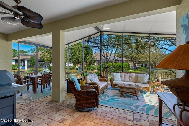 sunroom with vaulted ceiling with beams and a ceiling fan