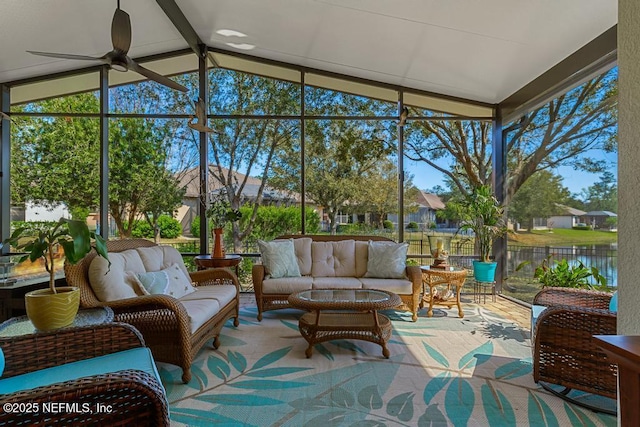 sunroom / solarium featuring lofted ceiling with beams, a water view, and a ceiling fan