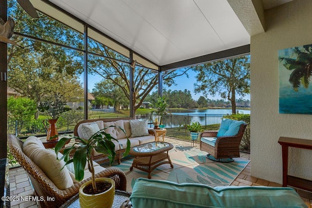 sunroom featuring a water view