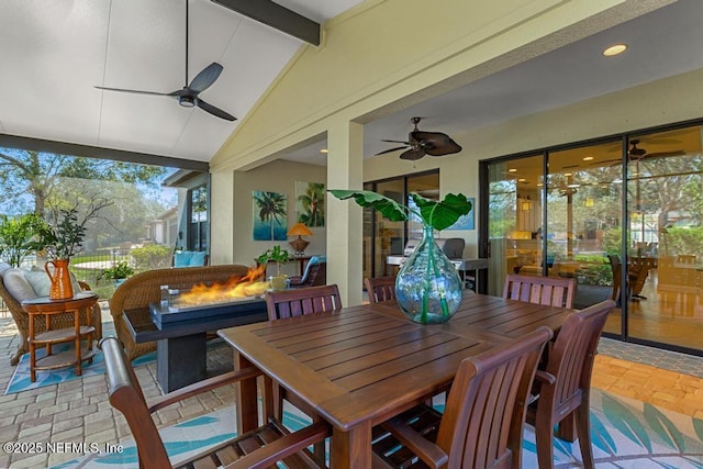 sunroom with lofted ceiling with beams and ceiling fan