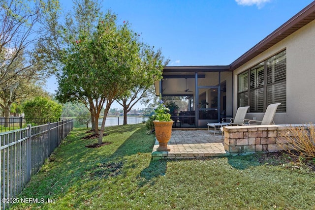 view of yard featuring a patio, a water view, a fenced backyard, and a sunroom