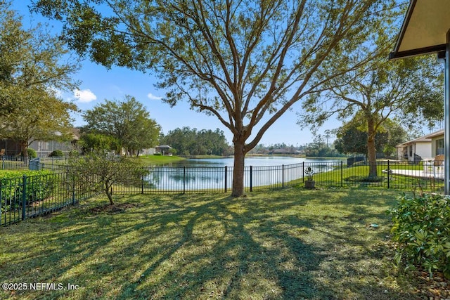 view of yard featuring a water view and fence