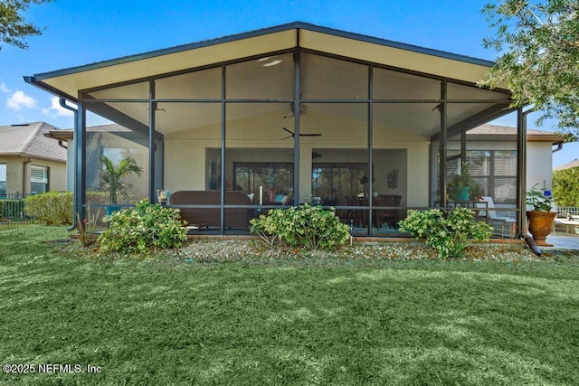 rear view of property featuring a lawn and a sunroom