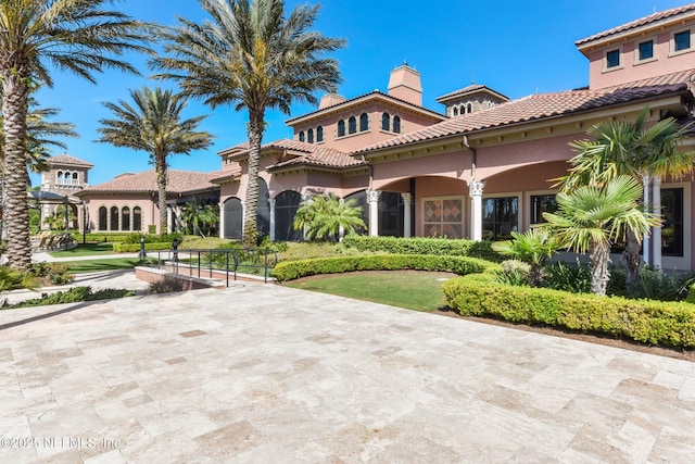 mediterranean / spanish home with a chimney and stucco siding