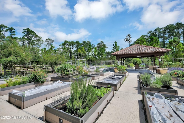 view of property's community with a gazebo, fence, and a garden