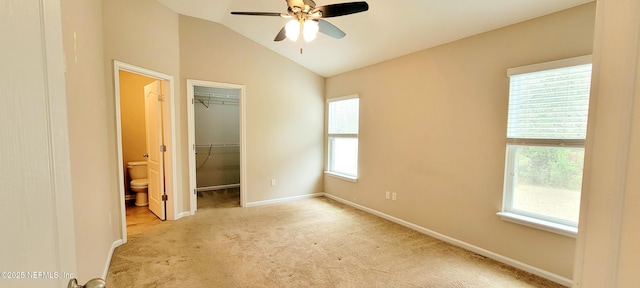 unfurnished bedroom featuring baseboards, carpet floors, vaulted ceiling, a spacious closet, and a closet