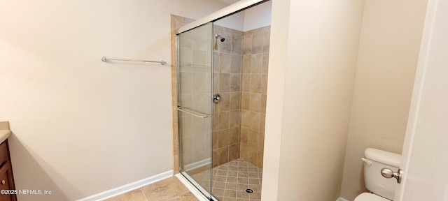 full bath featuring vanity, a shower stall, toilet, and baseboards