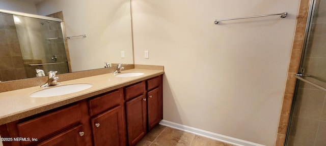 bathroom with double vanity, baseboards, a tile shower, and a sink